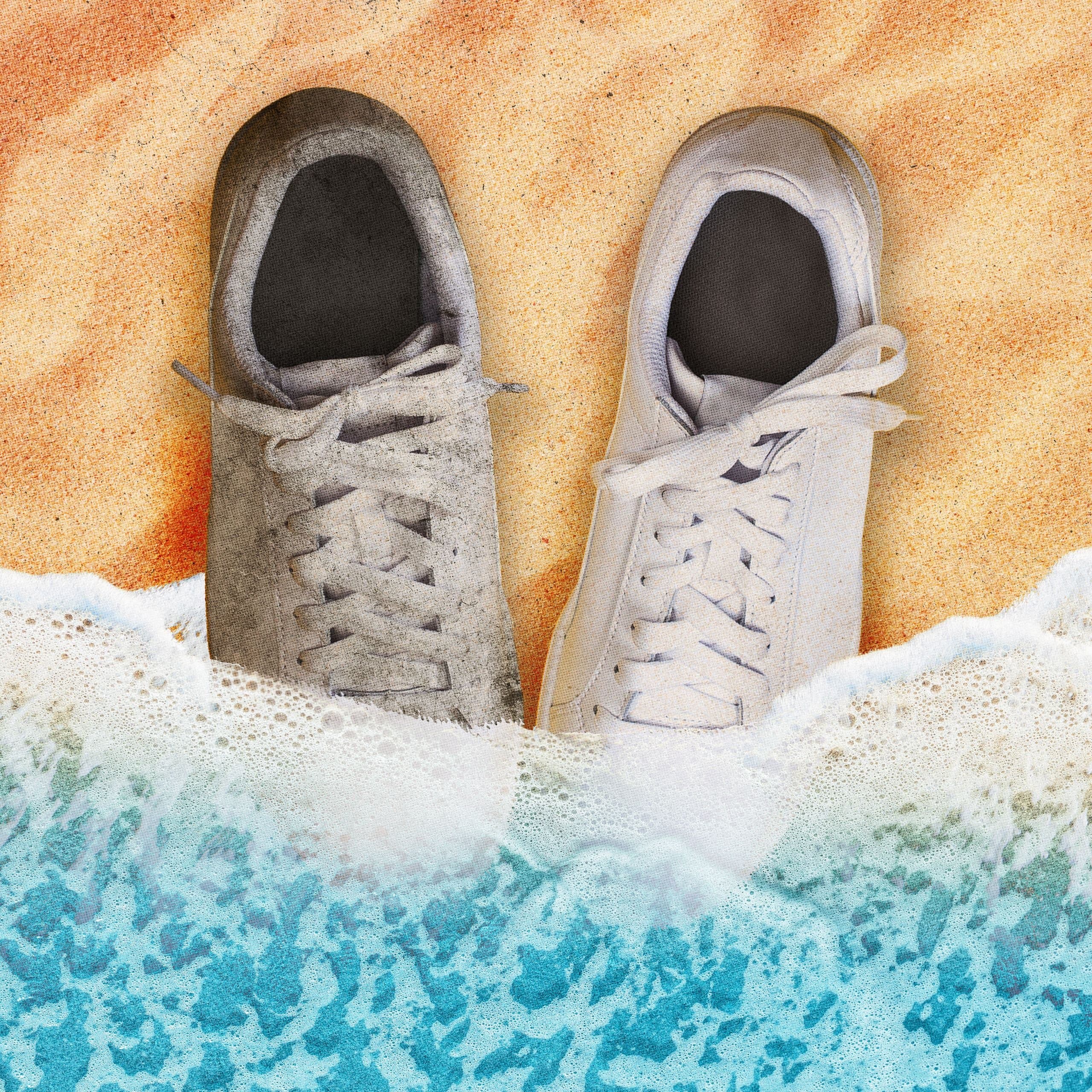 A pair of white sneakers being cleaned with a brush