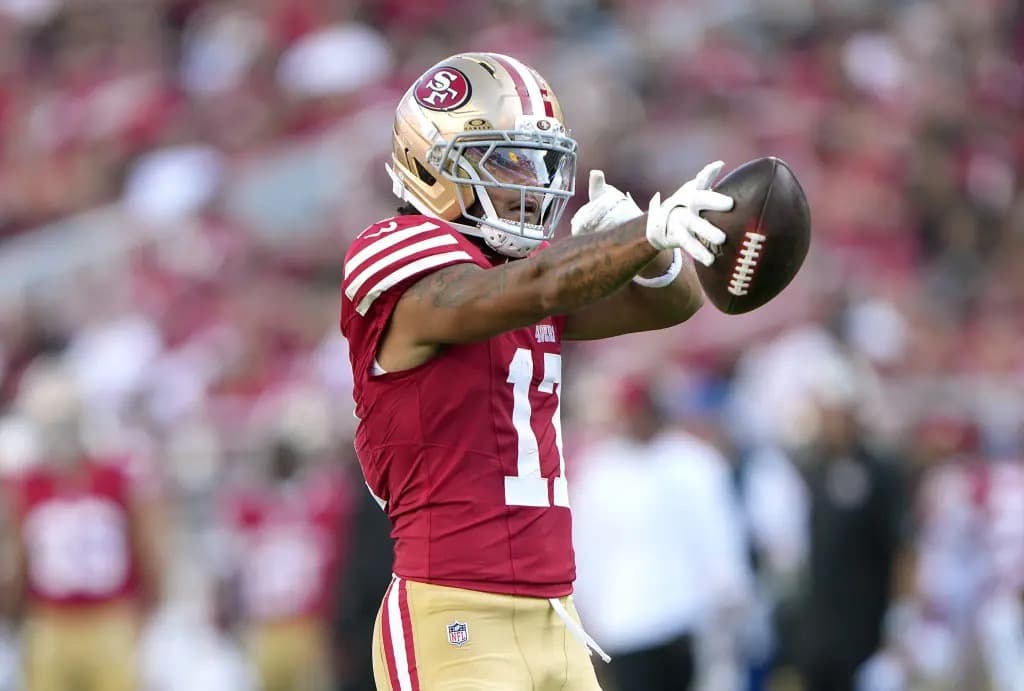San Francisco 49ers player in full uniform catching a football during a game